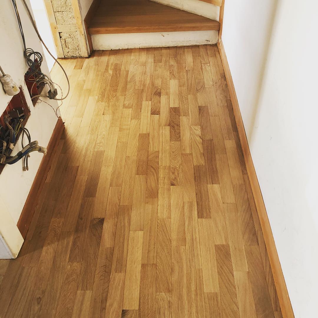 Pavimento in legno nel corridoio che conduce alla scala. Legno naturale, marrone chiaro.