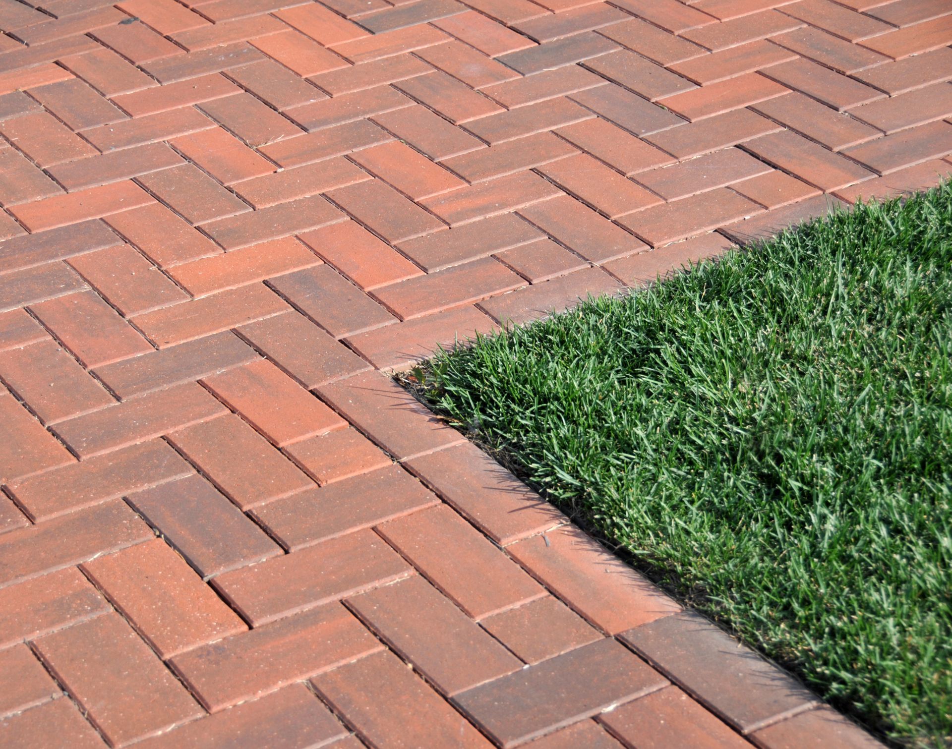 A person wearing gloves using a trowel to lay bricks, constructing a wall.
