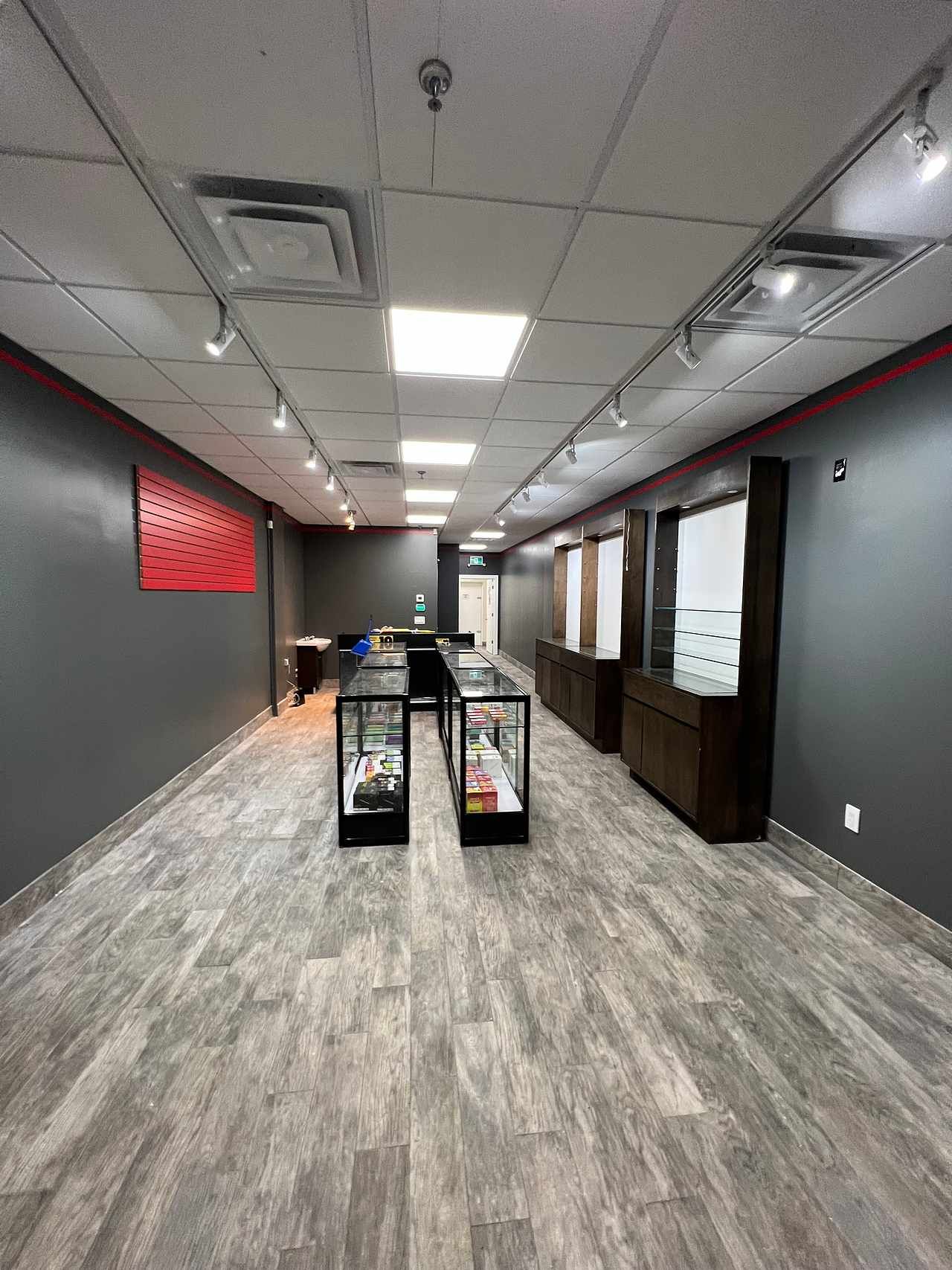 A large empty room with a wooden floor and a lot of display cases.