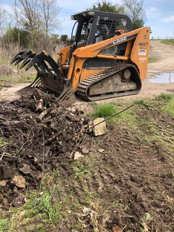 A yellow excavator is sitting on top of a pile of gravel.