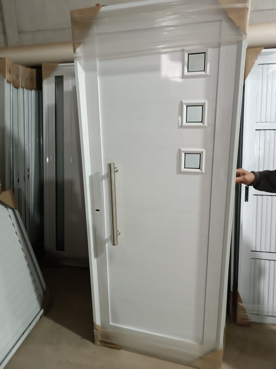 Una persona está abriendo una puerta blanca en una habitación.