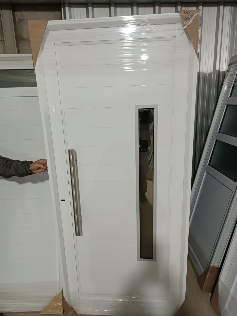 Una persona está parada junto a una puerta blanca en un almacén.