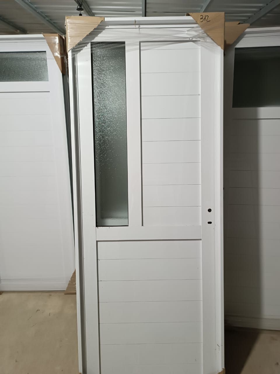 Una puerta blanca con una ventana de vidrio está en una habitación.