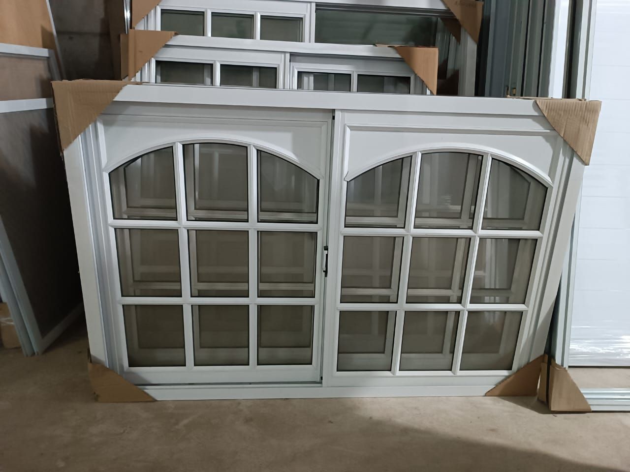 Una ventana blanca está en una habitación rodeada de otras ventanas.