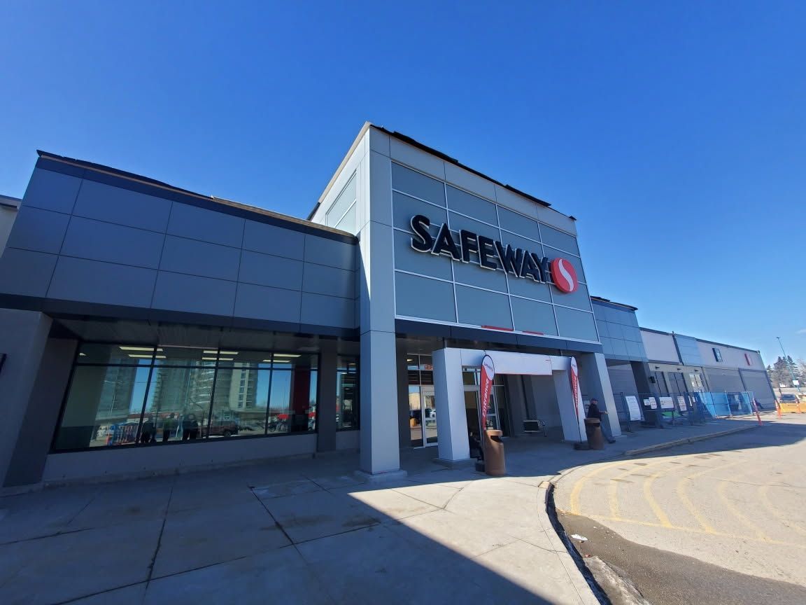 Modern building with metallic facade and glass windows against a blue sky.