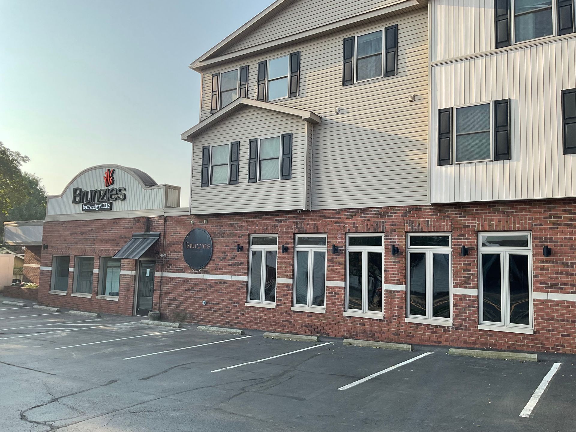 A two-story brick building with windows and the Brunzies sign