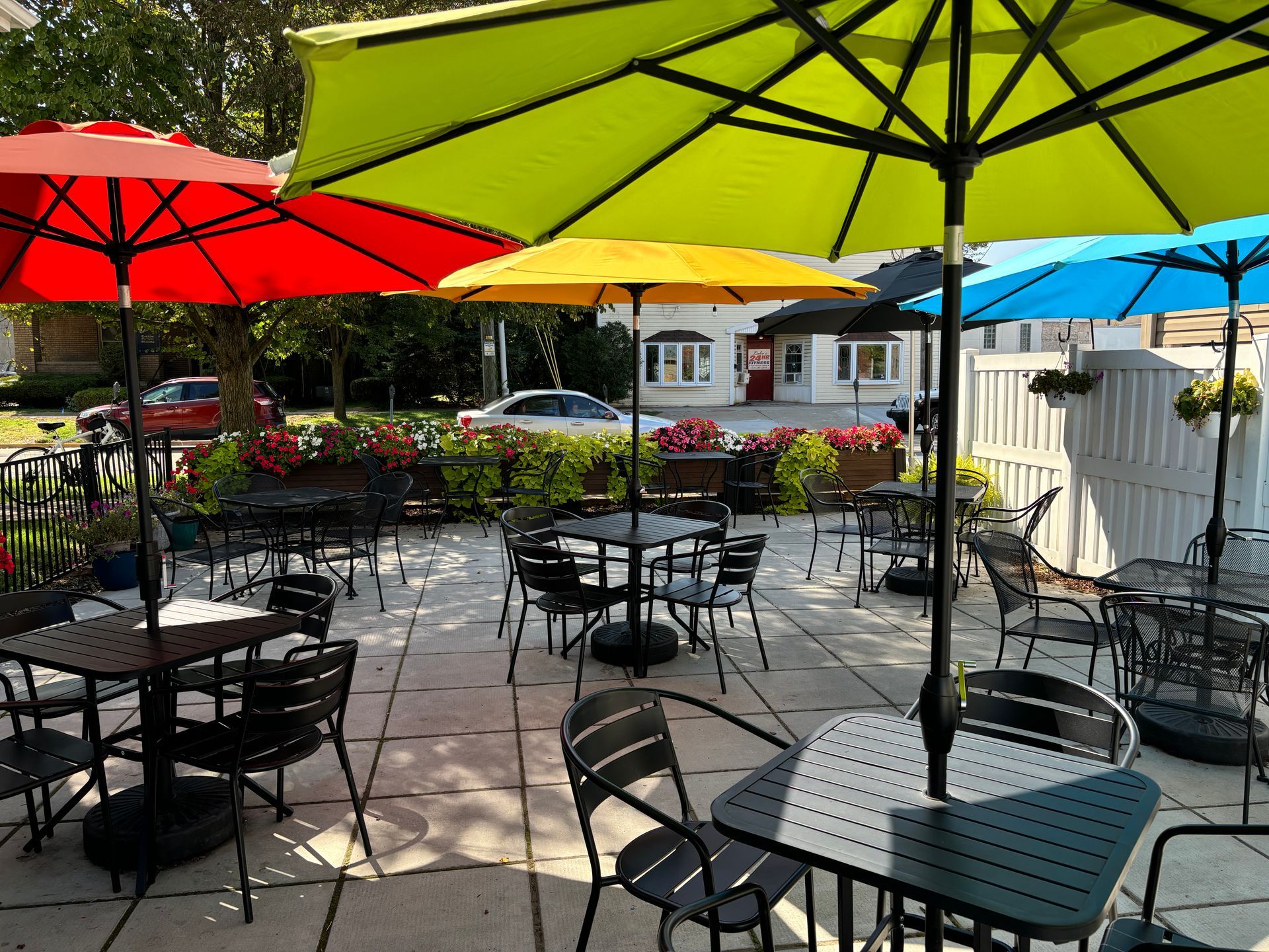 Outdoor restaurant patio with colorful umbrellas and tables.