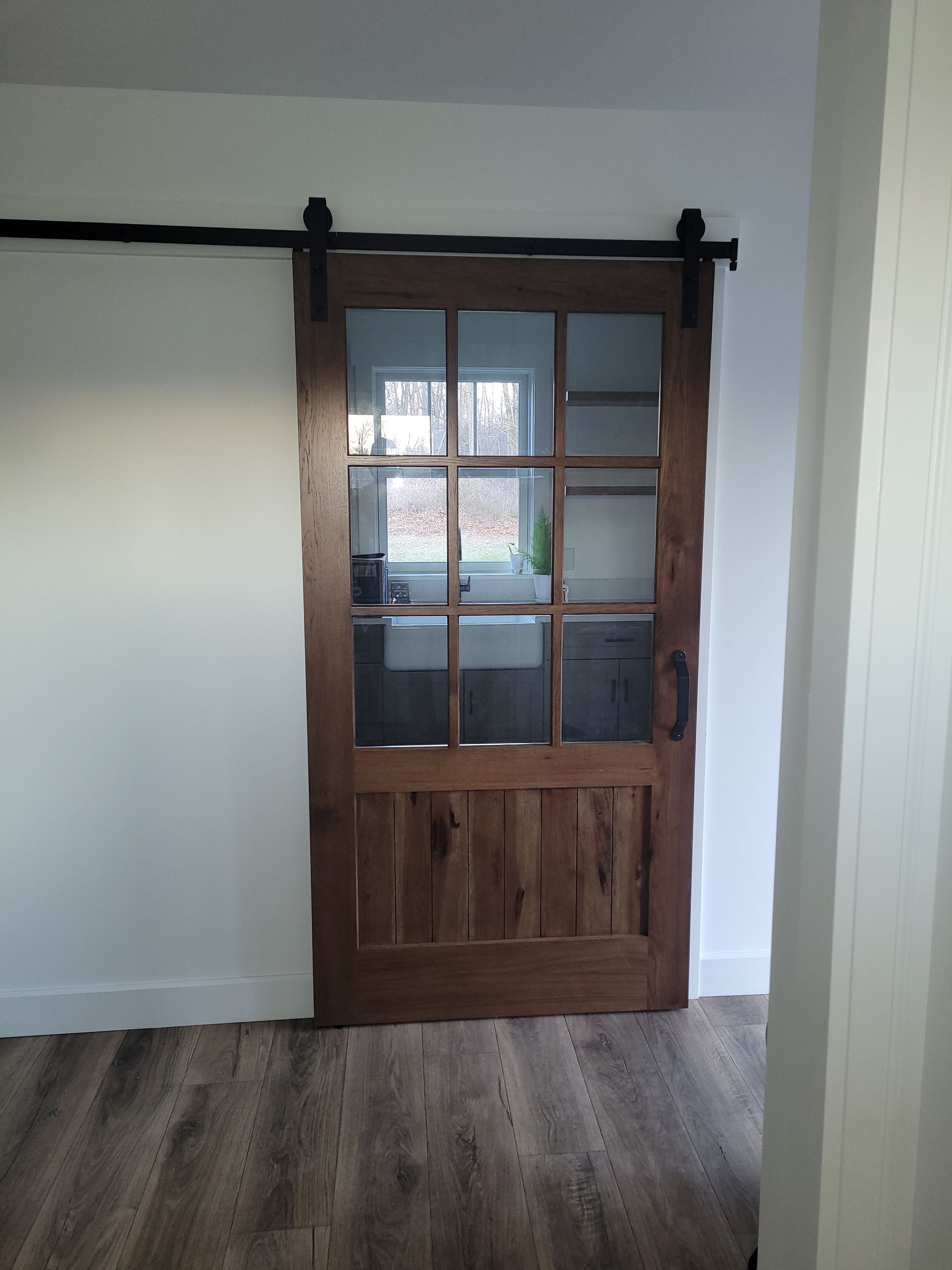 A Wooden Sliding Barn Door with Glass in A Room | Narvon, PA | JDH Custom Millwork