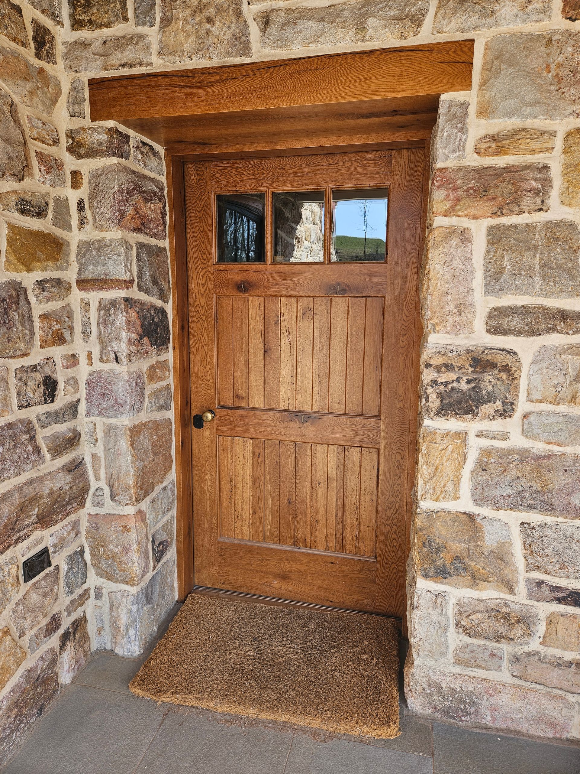 A Wooden Door Is Surrounded by A Stone Wall | Narvon, PA | JDH Custom Millwork