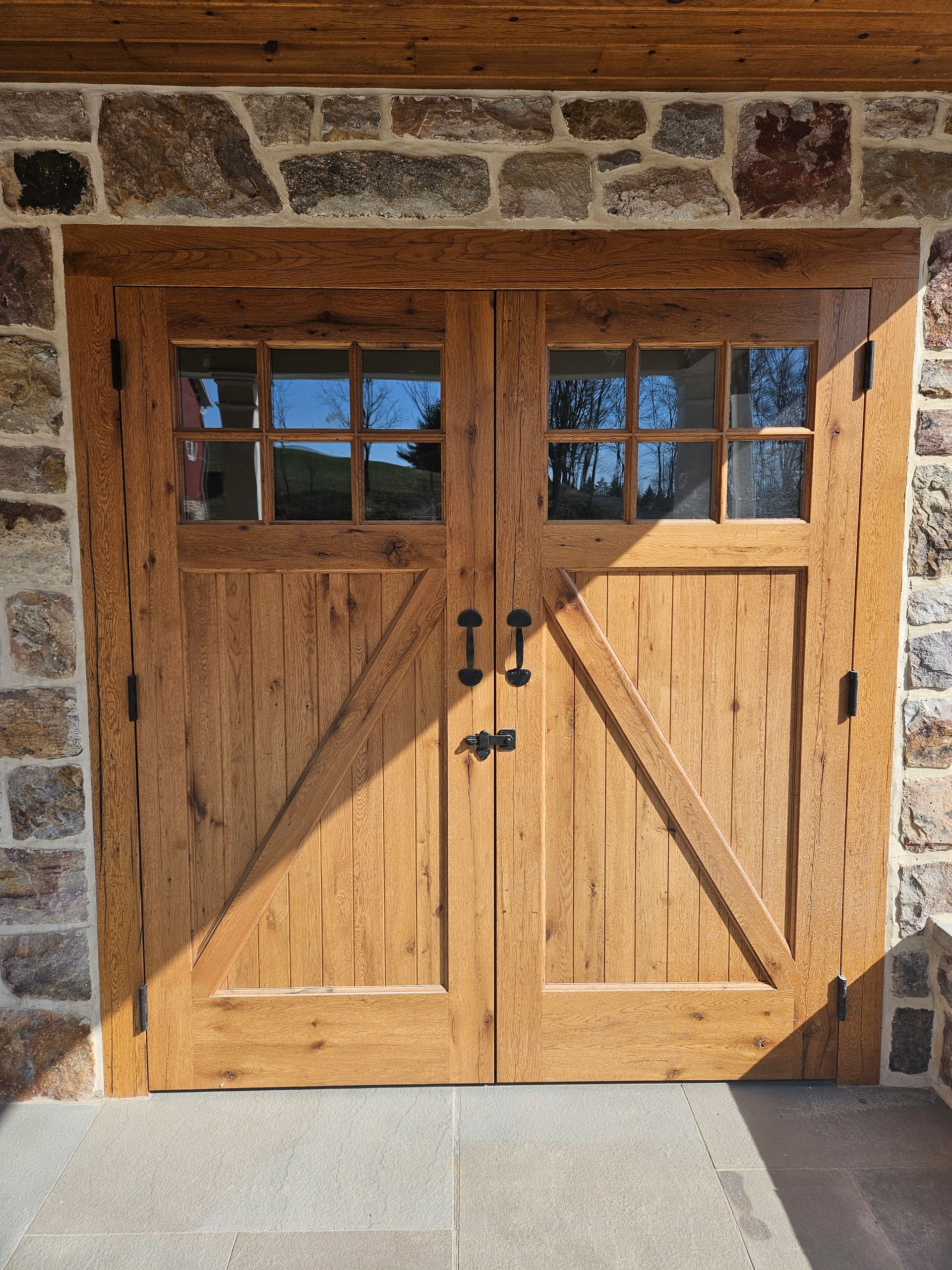 A Pair of Wooden Garage Doors Sitting on Top of A Stone Wall | Narvon, PA | JDH Custom Millwork