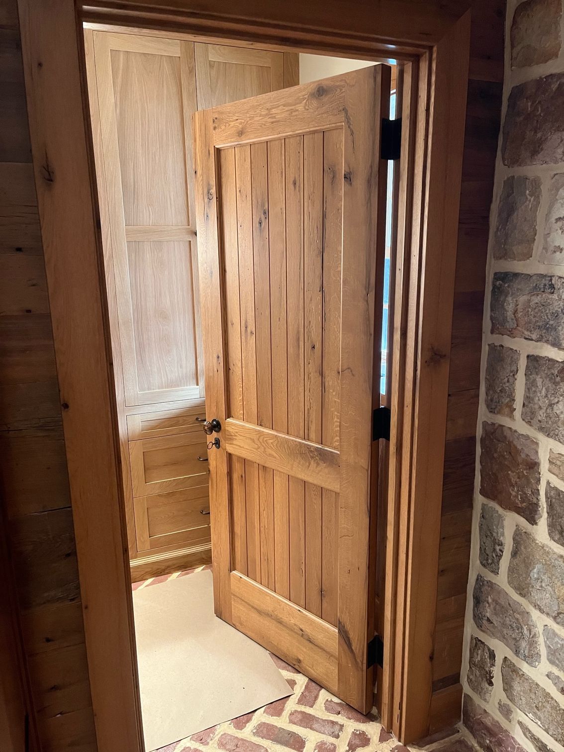 A Wooden Door Is Open in A Room with A Stone Wall | Narvon, PA | JDH Custom Millwork