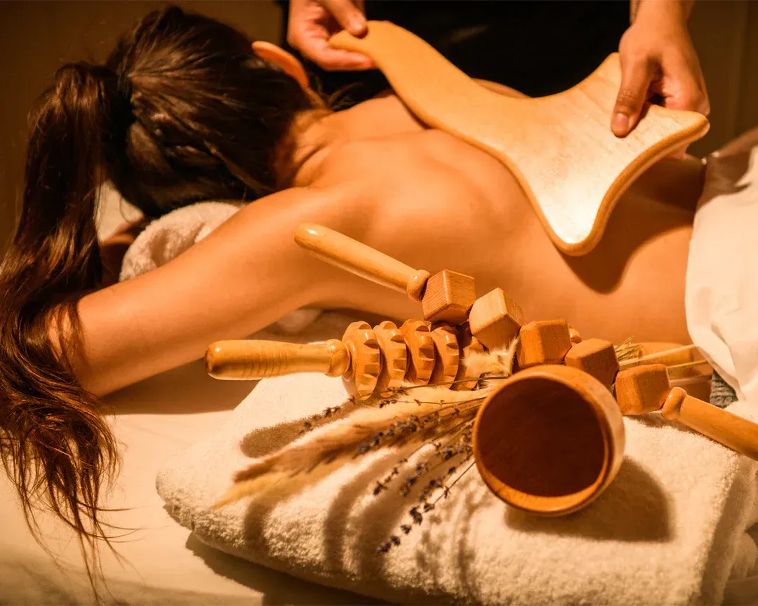Masajista trabajando en la espalda de un cliente en una luminosa sala de spa.