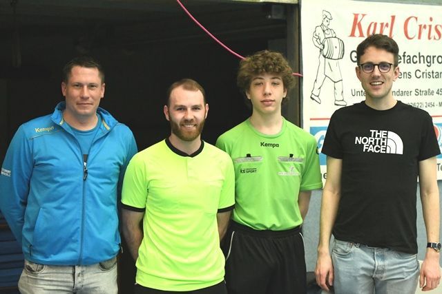 Vier Männer posieren für ein Foto vor einem Schild mit der Aufschrift „Karl Crisis“