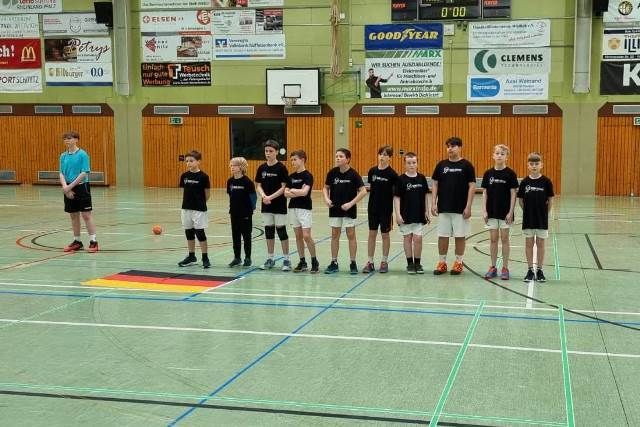 Eine Gruppe junger Jungen steht auf einem Basketballplatz.