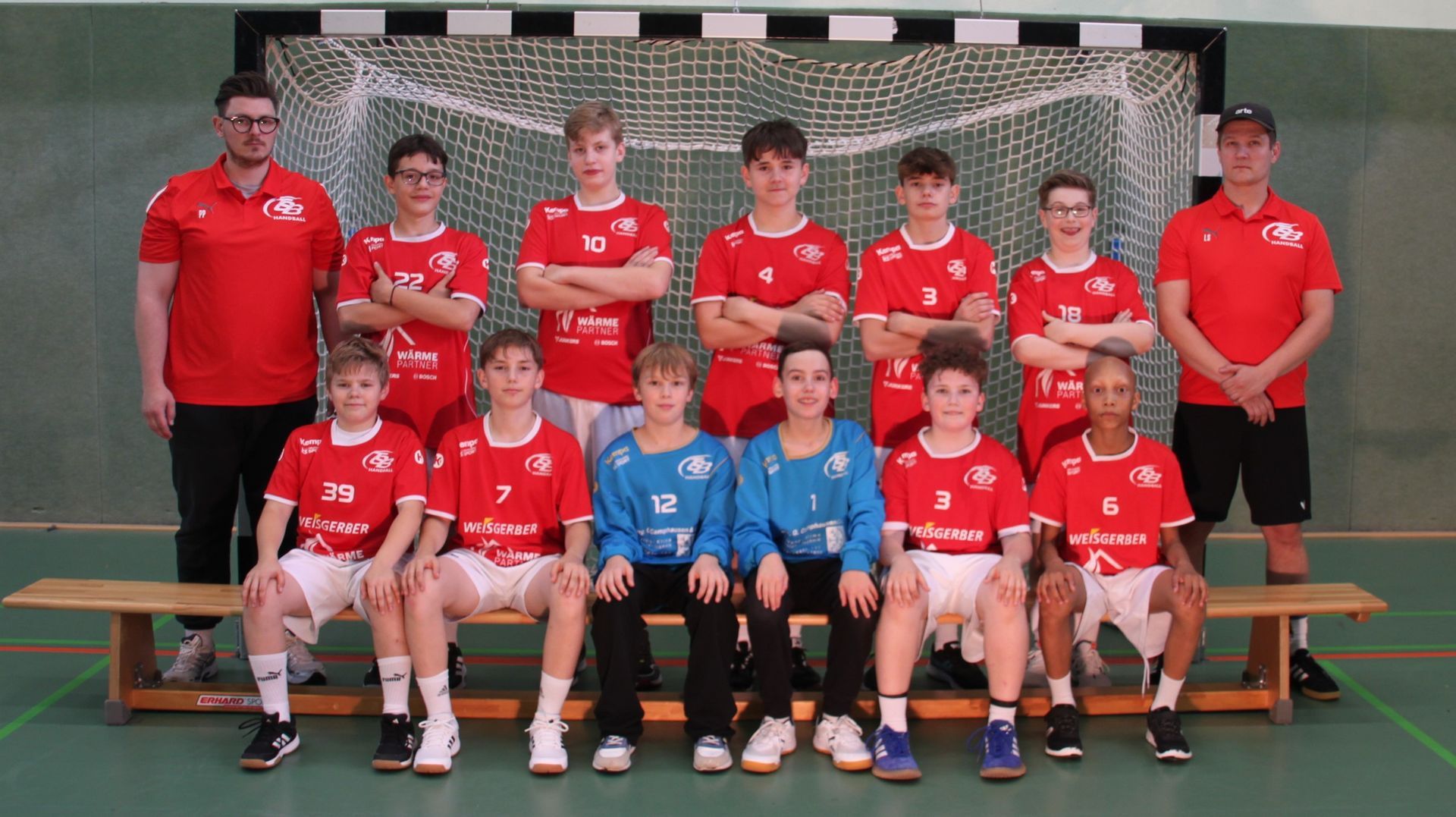 Eine Gruppe junger Jungen posiert vor einem Fußballtor für ein Foto.