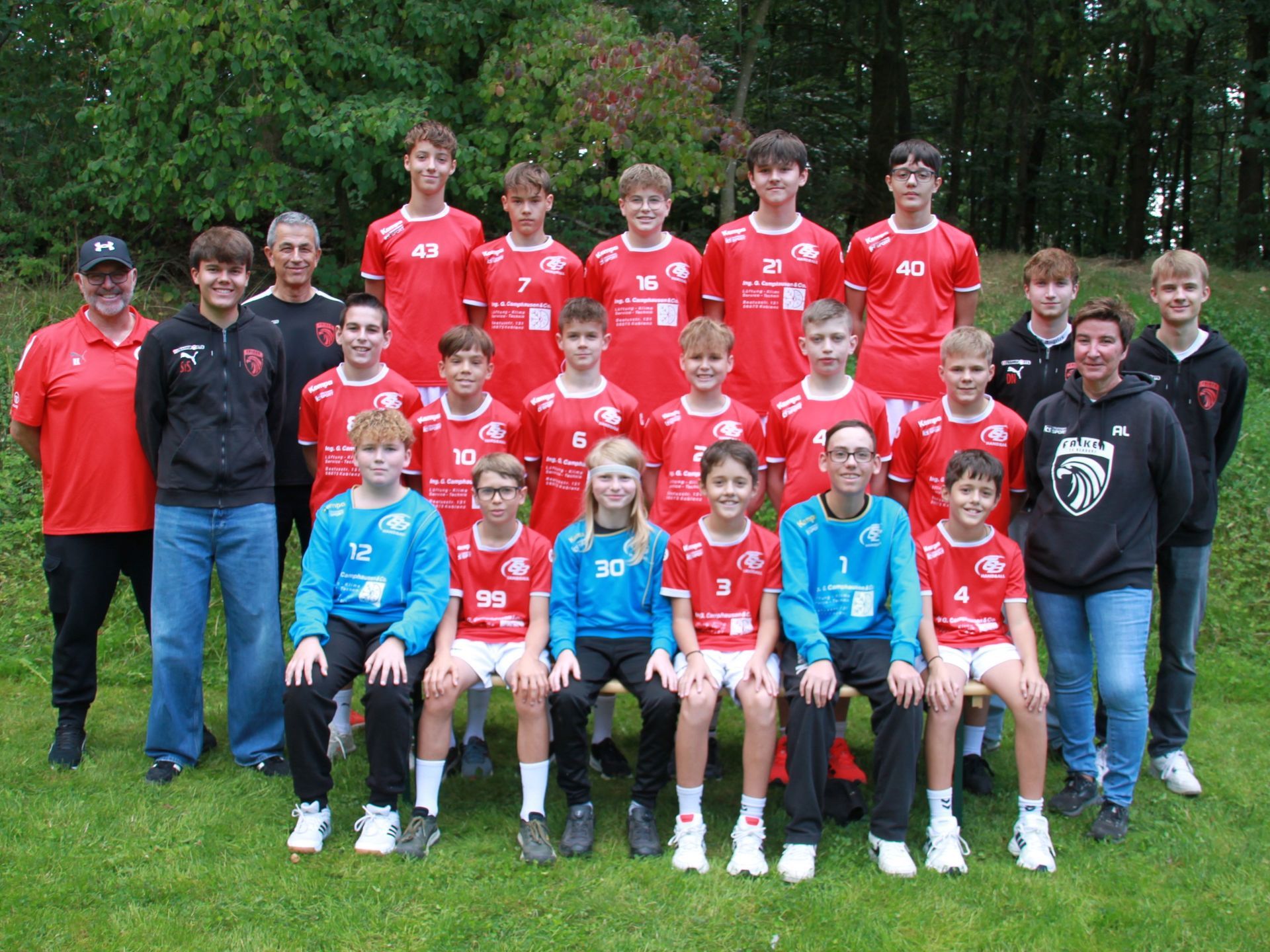 Eine Gruppe junger Jungen posiert vor einem Fußballtor für ein Foto.