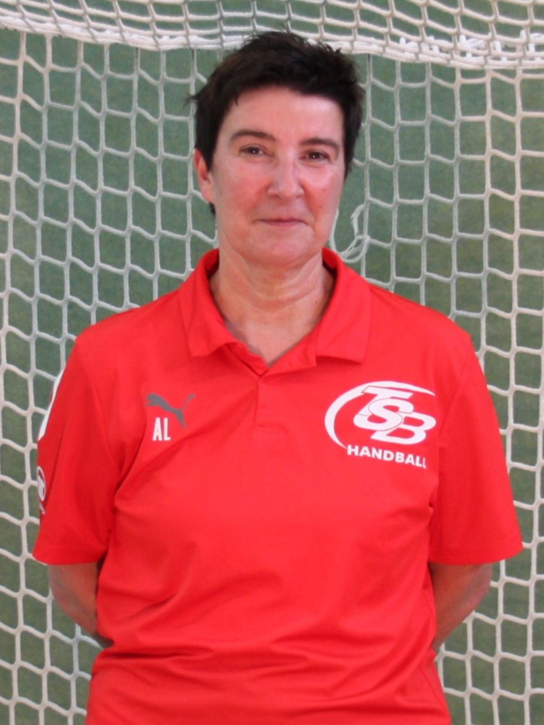 Ein Mann trägt ein rotes Hemd mit der Aufschrift „Handball“