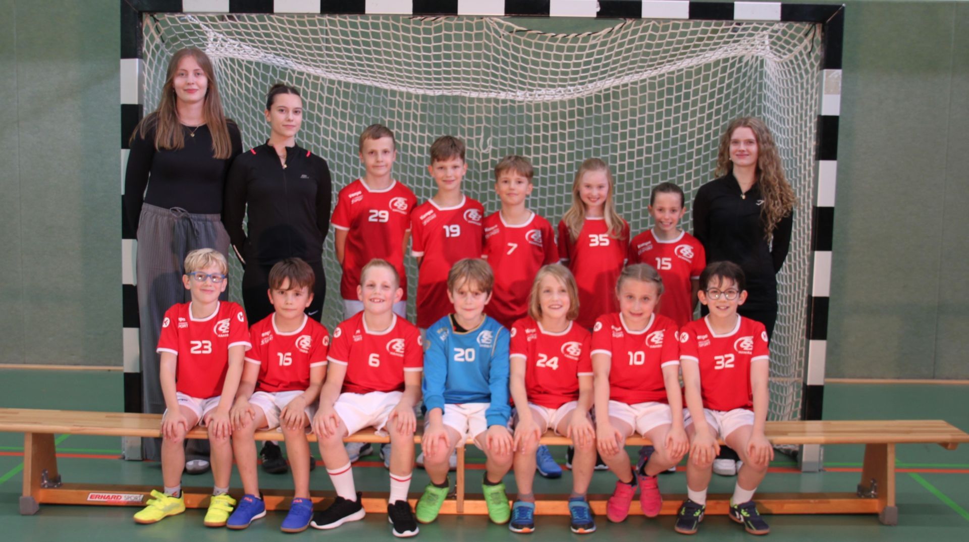 Eine Gruppe Kinder posiert vor einem Tor für ein Foto.