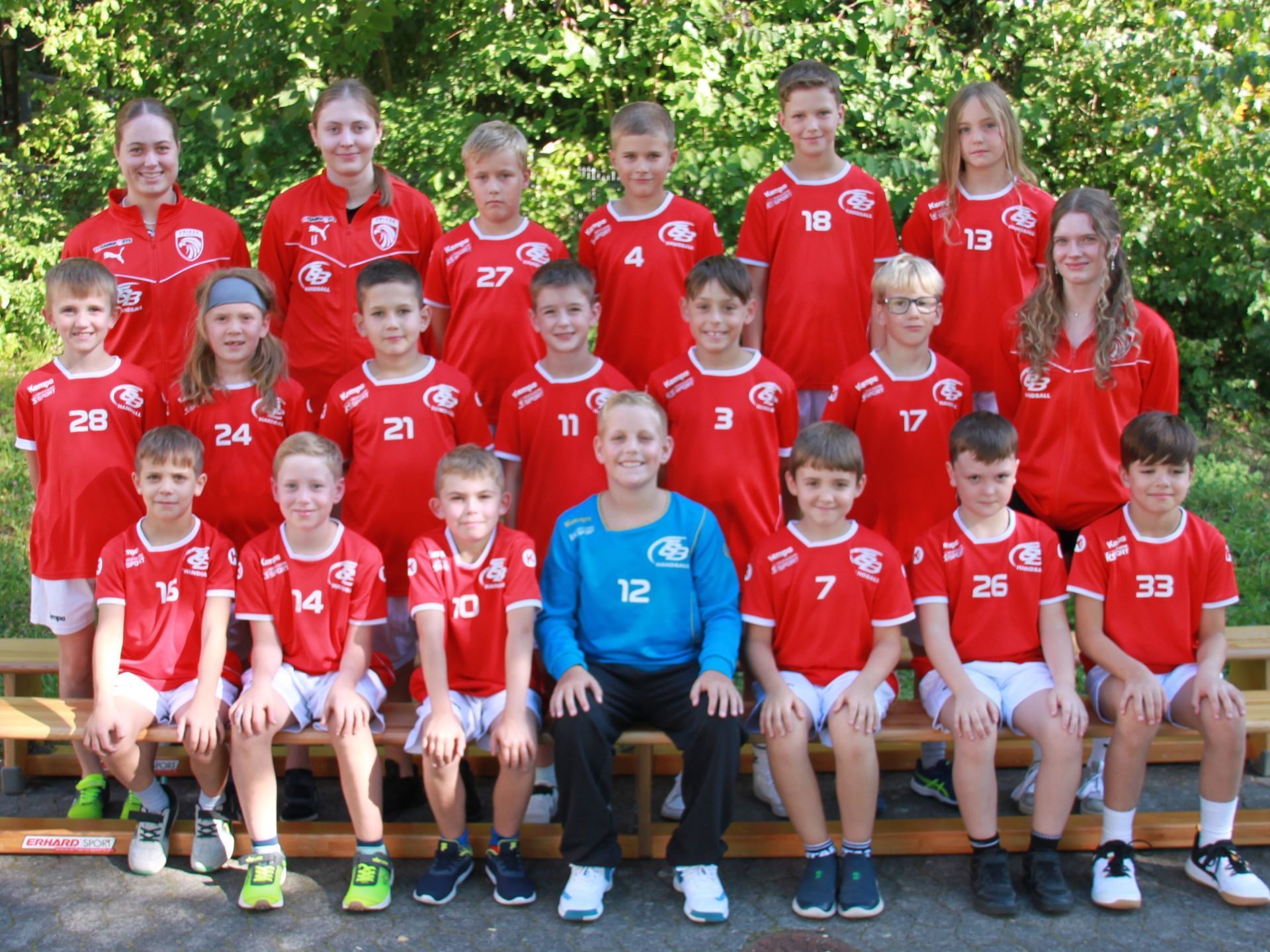 Eine Gruppe Kinder posiert vor einem Tor für ein Foto.