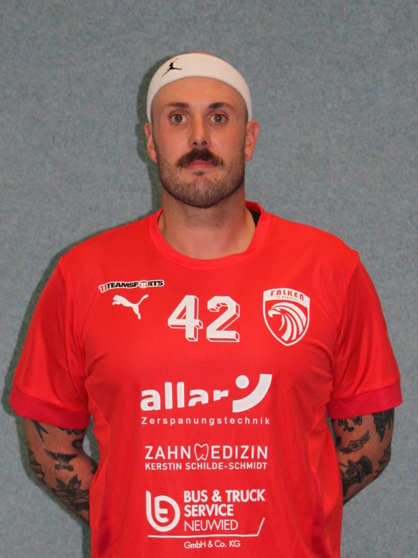 Ein Mann, der ein rotes Hemd mit dem Buchstaben G darauf trägt