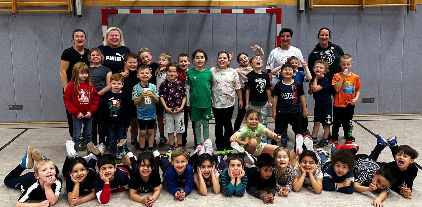 Eine Gruppe Kinder posiert mit Fußbällen für ein Foto.