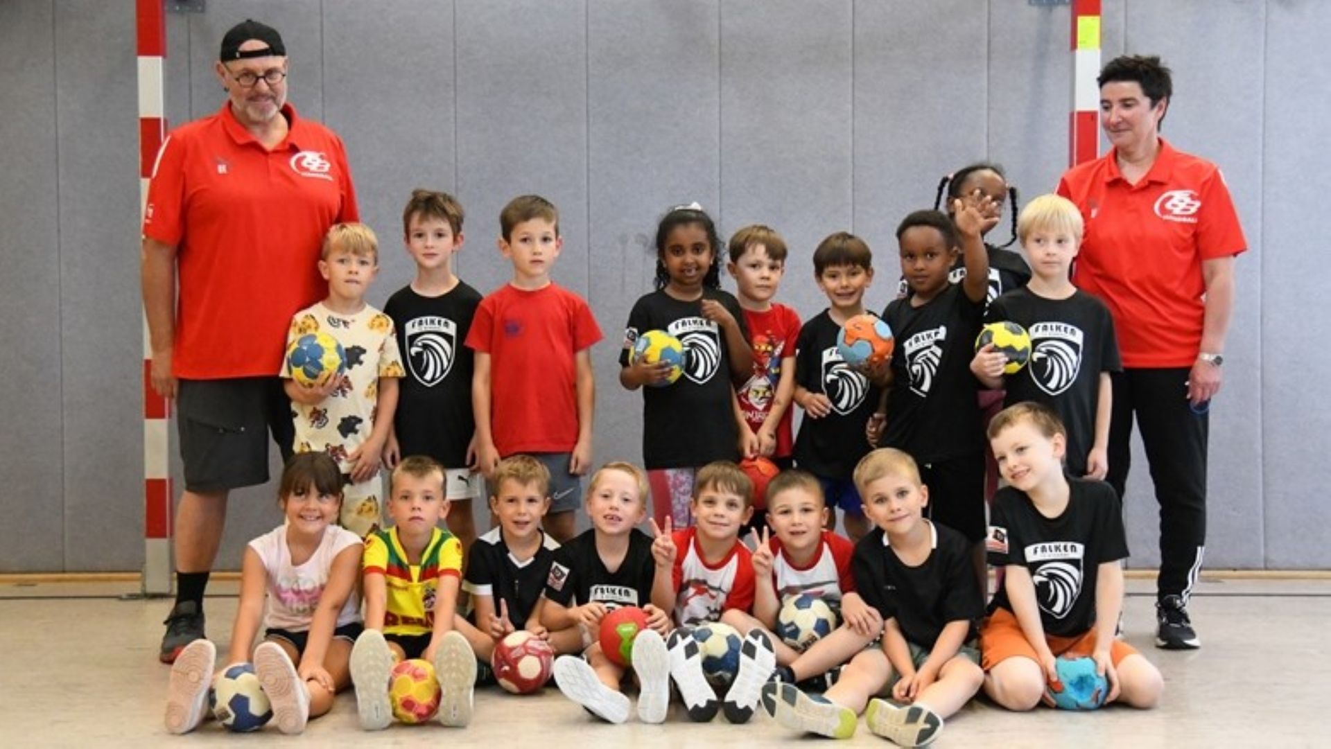 Eine Gruppe Kinder posiert mit Fußbällen für ein Foto.