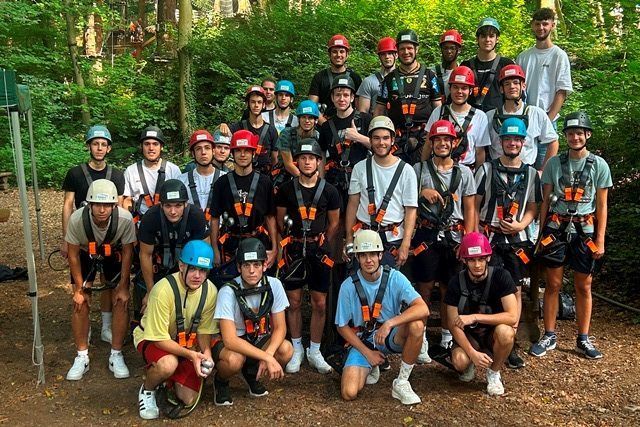 Eine Gruppe junger Männer mit Helmen und Gurten posiert für ein Foto.