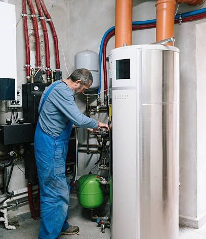 Plumber working on a basement utility system