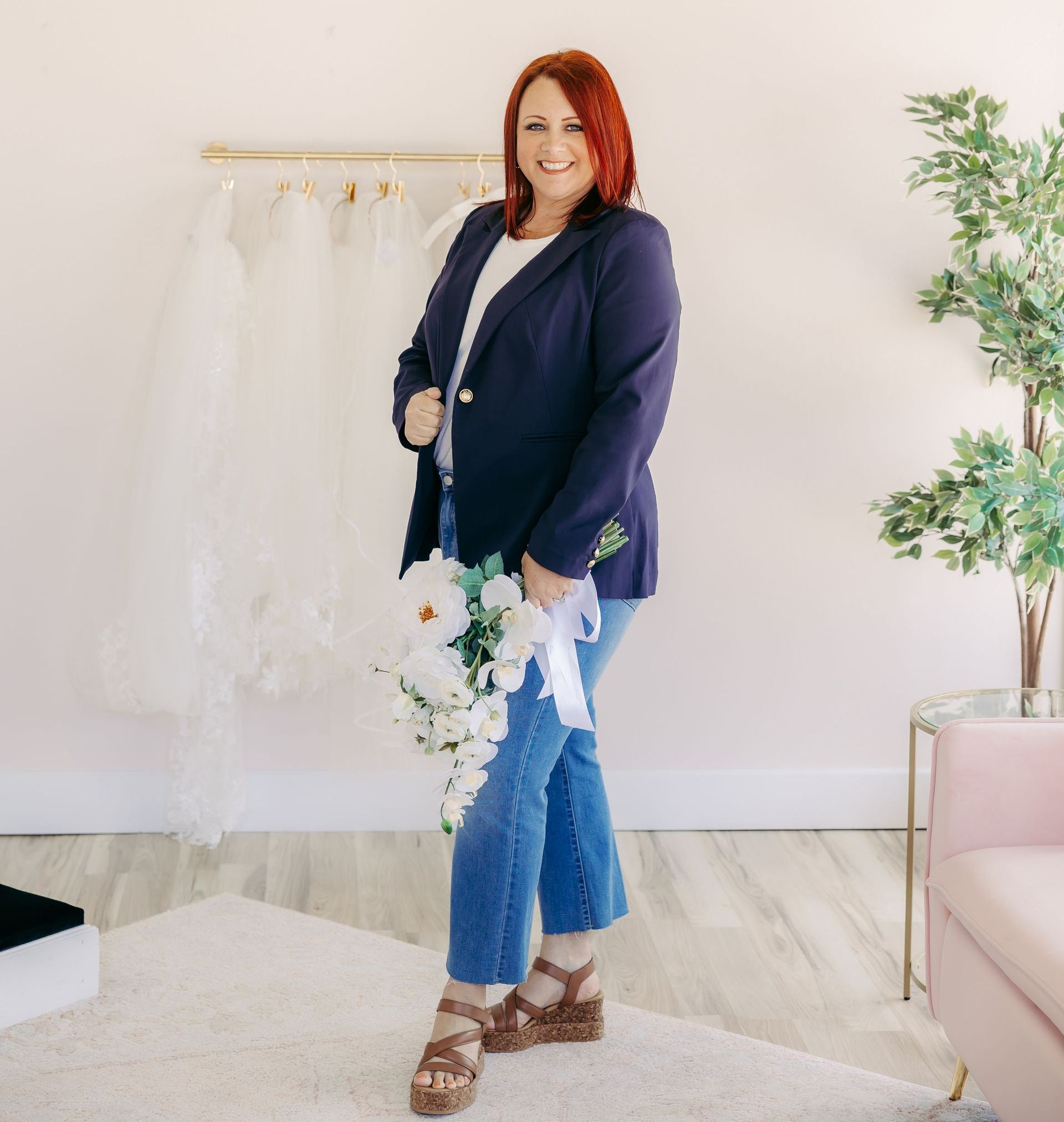 A woman is standing in a room holding a bouquet of flowers.