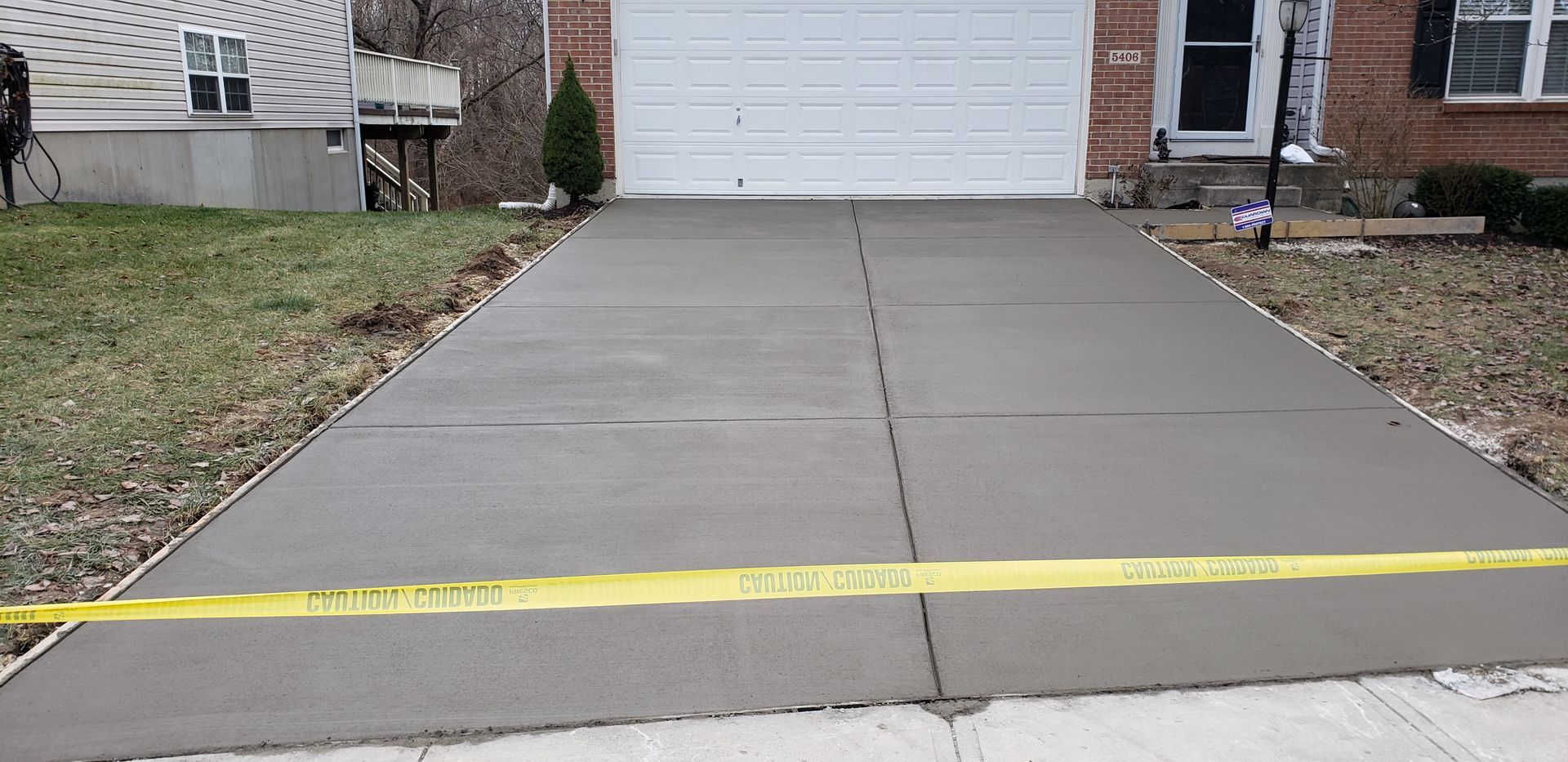 A concrete driveway is being built in front of a house.