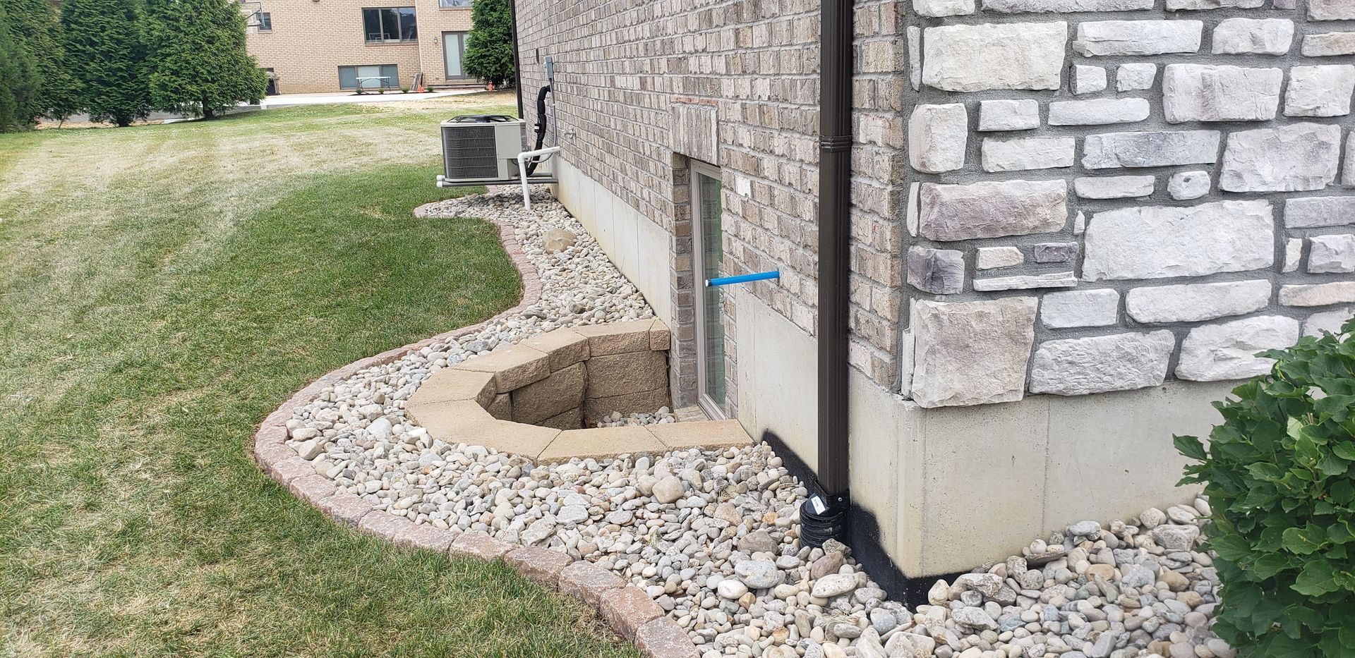 A brick building with a drain pipe on the side of it.