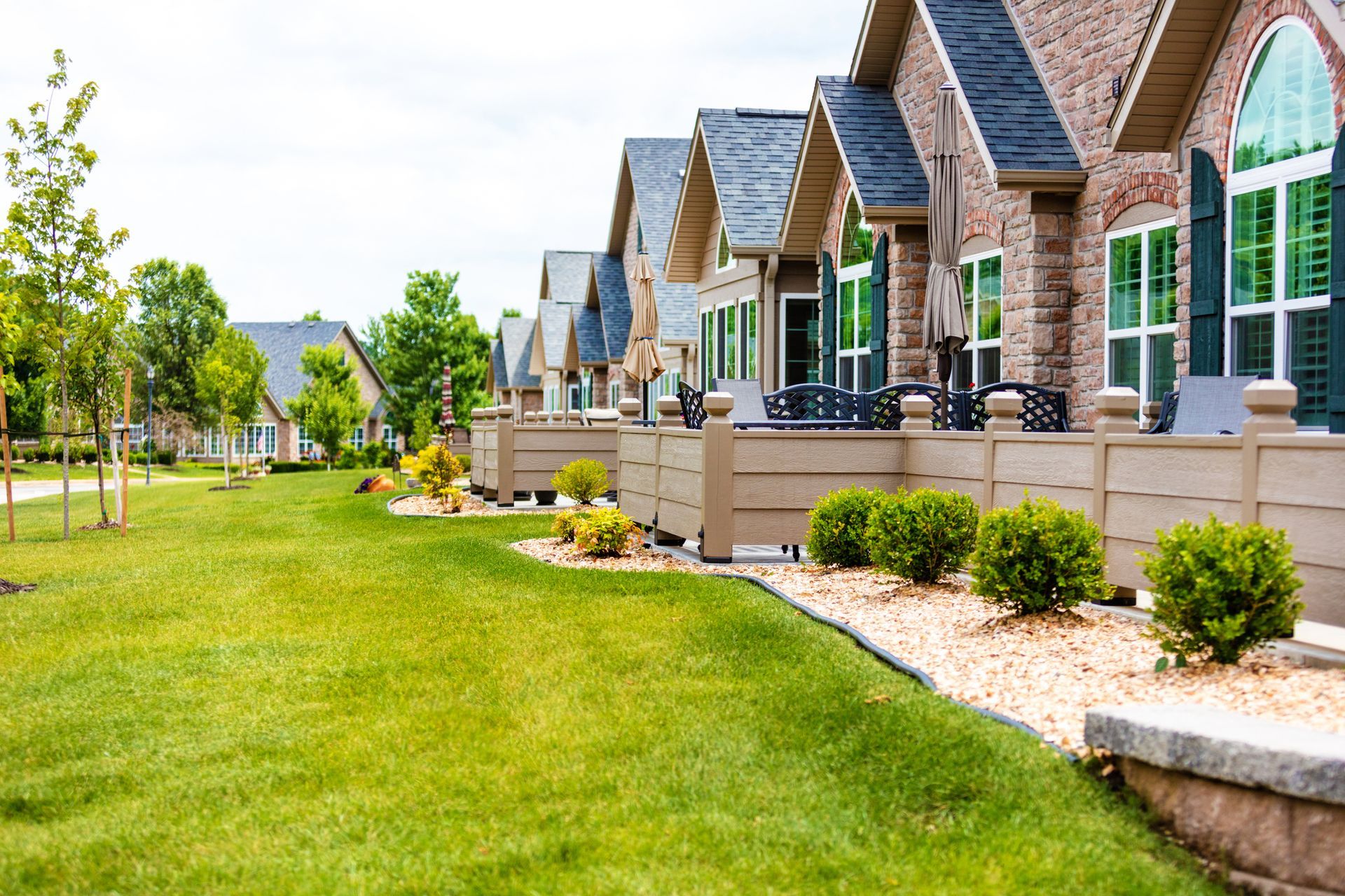 A row of houses with a lush green lawn in front of them.