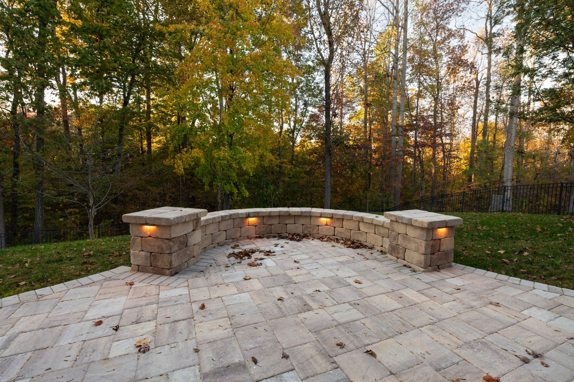 A patio with a bench and trees in the background.