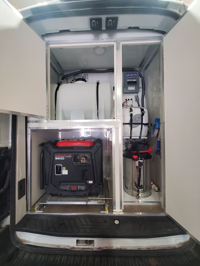 Interior view of a van, showing a generator, water tank, and equipment.