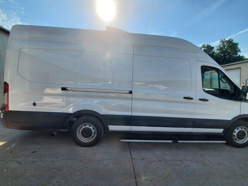 White cargo van parked outside on a sunny day.