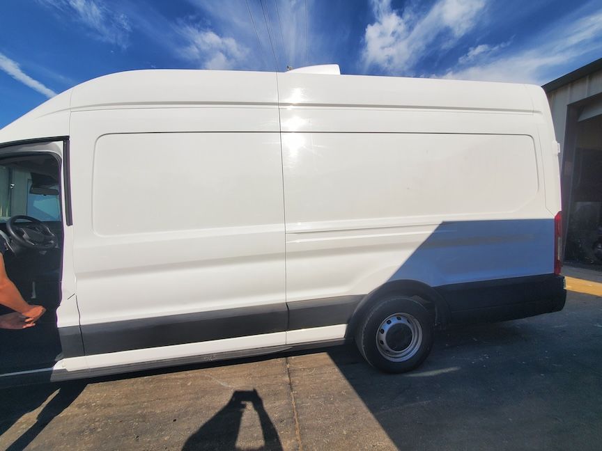 White cargo van parked outdoors on a sunny day.