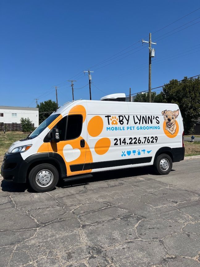 White and orange mobile pet grooming van with