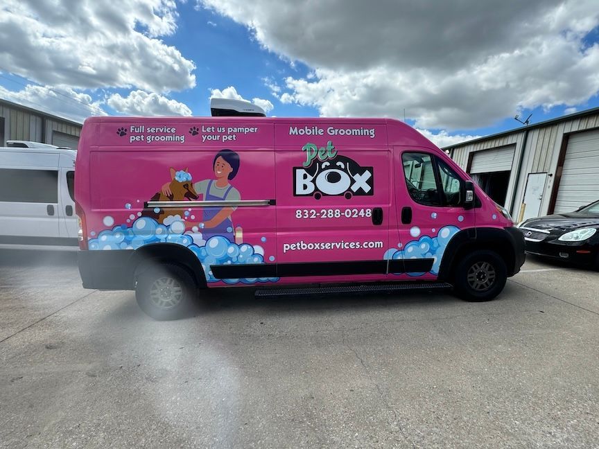 Pink mobile grooming van with logo