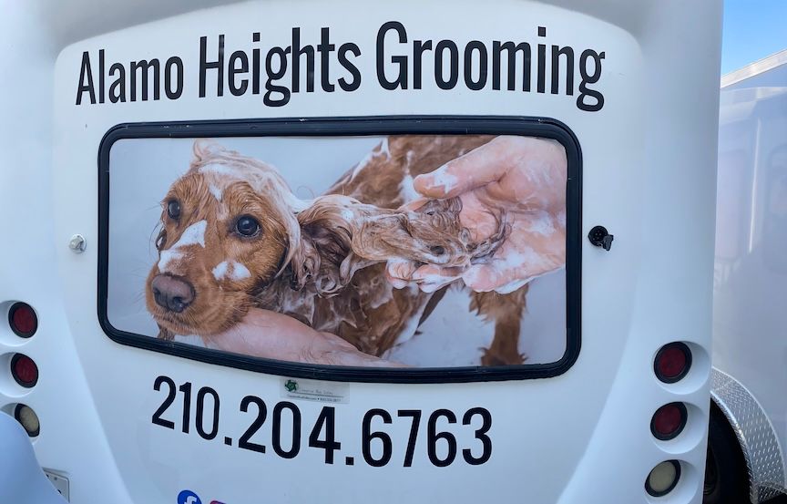 Alamo Heights Grooming sign with a dog being washed; phone number is 210.204.6763.