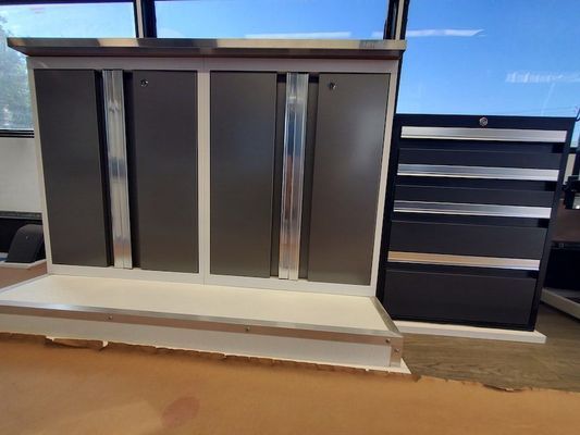 A gray and white cabinet with drawers in a room