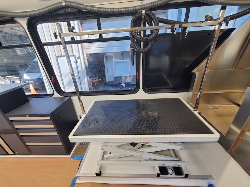 A white table with a black top is sitting in a room next to a window.