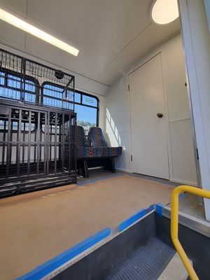 The inside of a bus with a cage and stairs