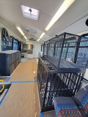 The inside of a bus with a cage in the back.