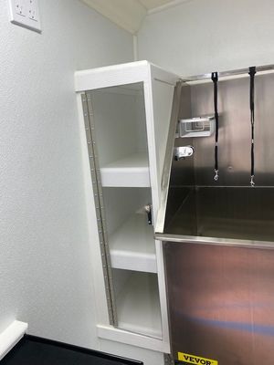 A bathroom with a sink and shelves in it.