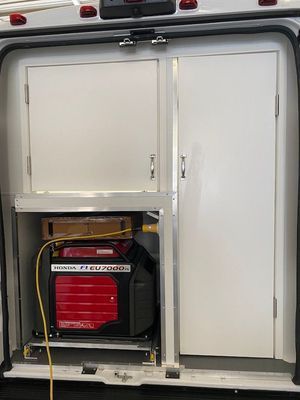 A generator is sitting in the back of a van.