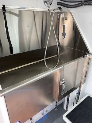 A stainless steel sink with a hose attached to it.