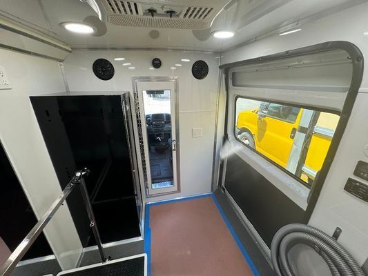 The inside of a bus with a yellow truck in the background.