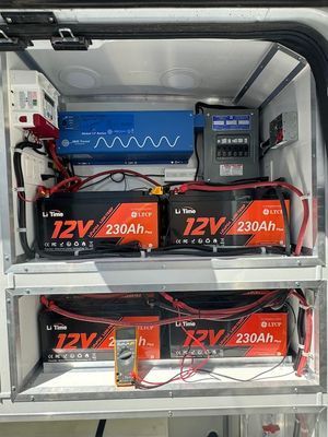 A bunch of batteries are sitting on top of a shelf in a van.