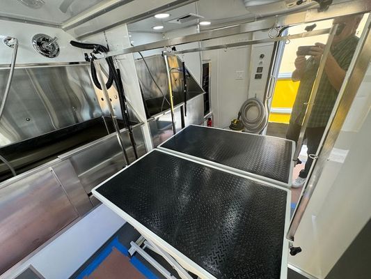 A dog grooming van with a black table in the middle