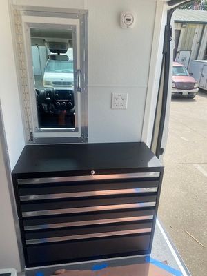 A black dresser with drawers and a mirror in a van.